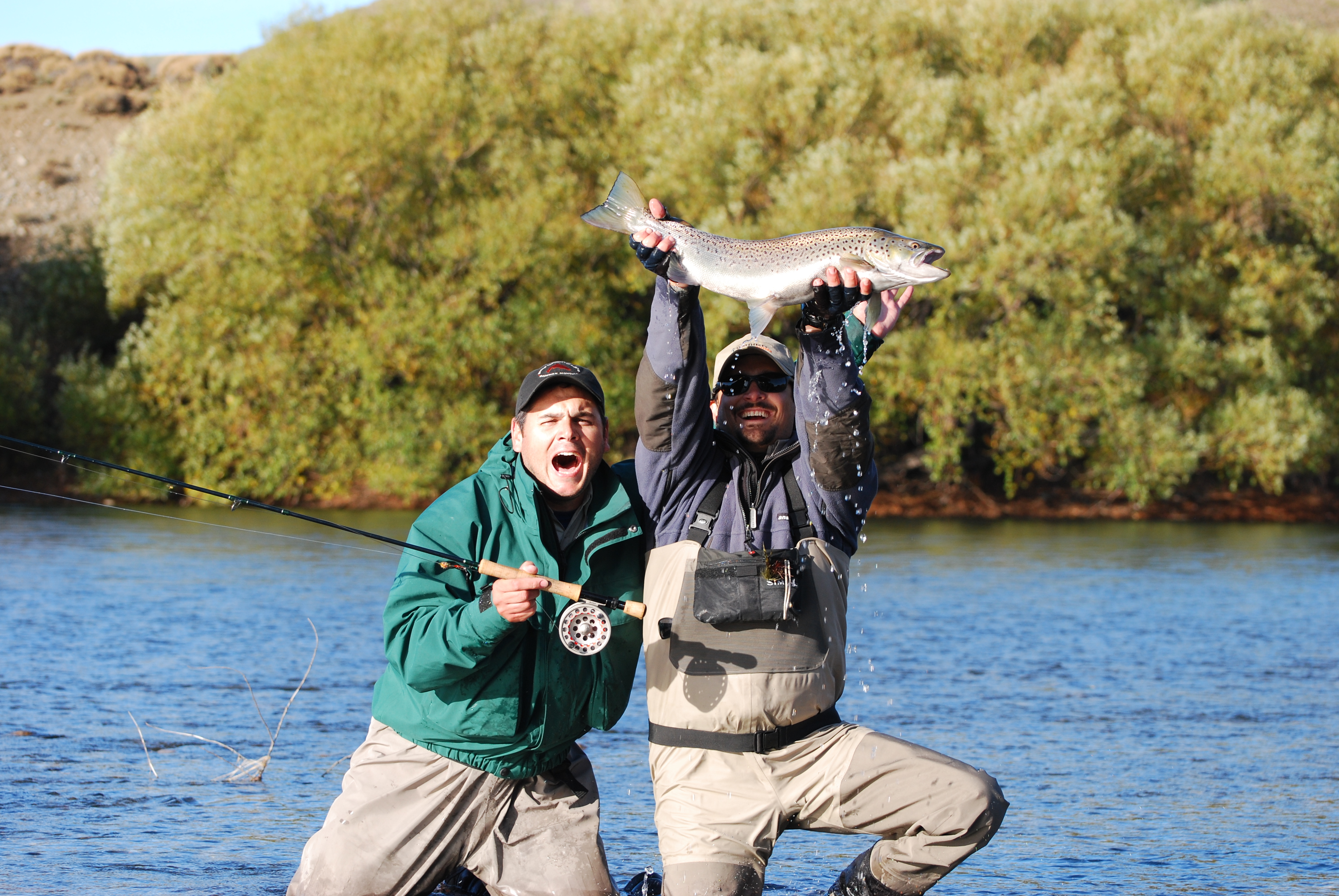 Two fishermen with a fish caught in Patagonia Argentina